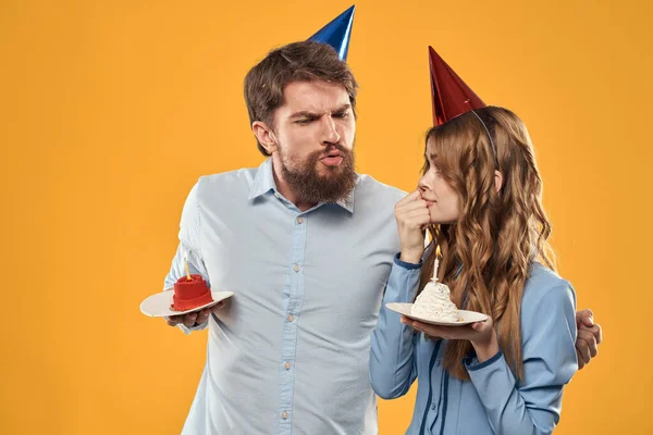Doğum günü partisi erkeği ve kadın eğlence sarı arka plan şapka tatili — Stok fotoğraf