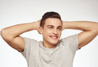 Gri bir Stüdyo tişörtü giymiş neşeli bir adam.