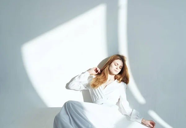 Mulher romântica em um vestido de verão dentro de casa e luz caindo na parede — Fotografia de Stock