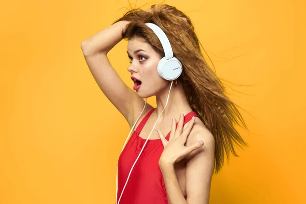 Veselá žena ve sluchátkách hudba životní styl žluté pozadí — Stock fotografie