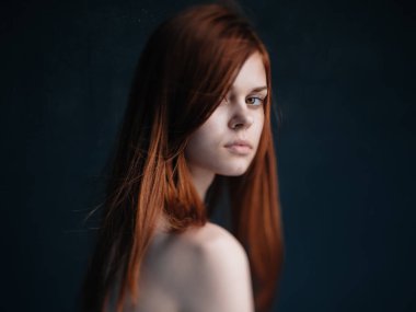 Siyah arka planda kızıl saçlı seksi bir kadın manken.