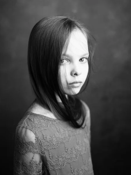 Portret dziewczynki w sukience na ciemnoszarym tle fotografia przycięty widok z boku — Zdjęcie stockowe