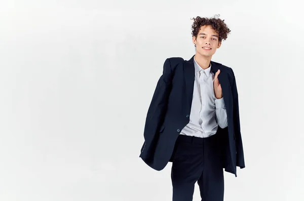 Έφηβος σε κλασικό κοστούμι με σακάκι στο χέρι και φως φόντο περικοπή άποψη του παντελονιού — Φωτογραφία Αρχείου
