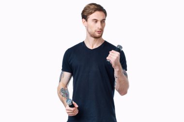 Elinde dambıllar olan siyah tişörtlü bir adam spor mankeni.