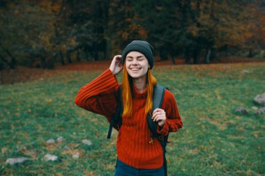 Kadın kırmızı kazağı yeşil çimen manzaralı seyahat modeli turizmi