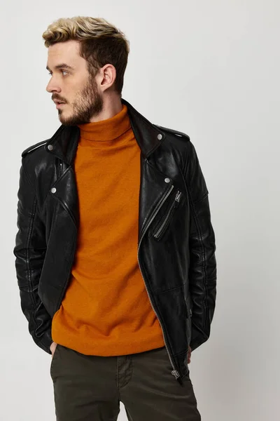 Hombre rubio en suéter naranja y chaqueta de cuero mirando a la vista lateral recortada —  Fotos de Stock