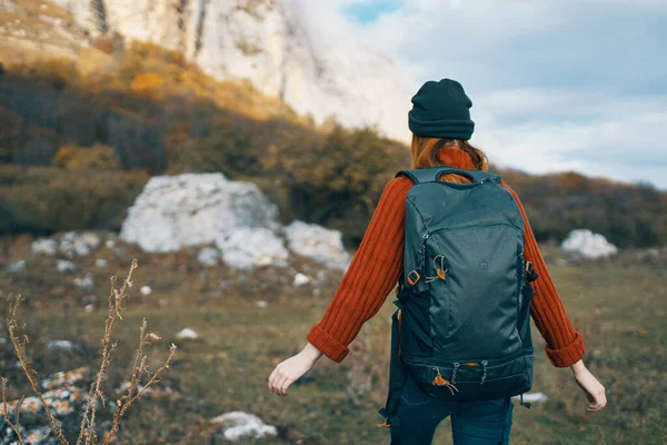 Donna turista in un cappello con uno zaino sale le montagne nella natura vista posteriore — Foto Stock
