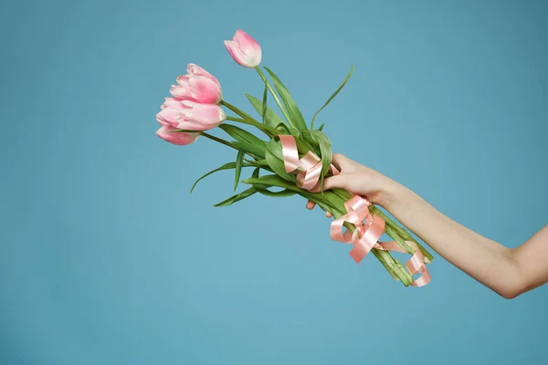 Букет квітів в руках святковий романтичний подарунок синій фон — стокове фото