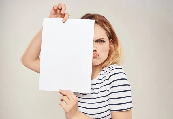 Blondine vrouw met een wit vel papier in de handen van een reclamebanner — Stockfoto