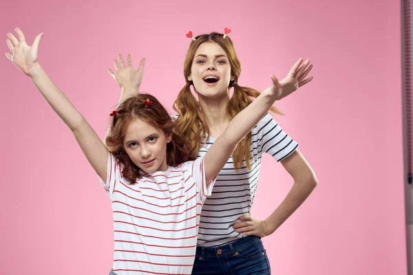 Γυναίκα και μικρό κορίτσι σε ροζ φόντο διασκέδαση αδελφές φίλους οικογένεια — Φωτογραφία Αρχείου