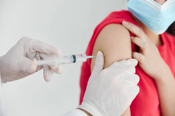 Médico en guantes médicos hace una inyección en los pacientes covid hombro vacunación —  Fotos de Stock