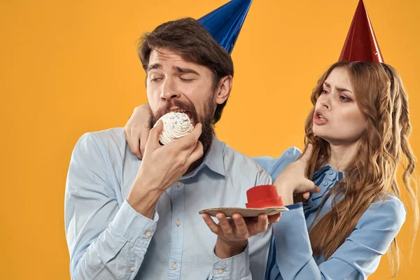 Aniversário festa homem e mulher diversão amarelo fundo cap feriado — Fotografia de Stock