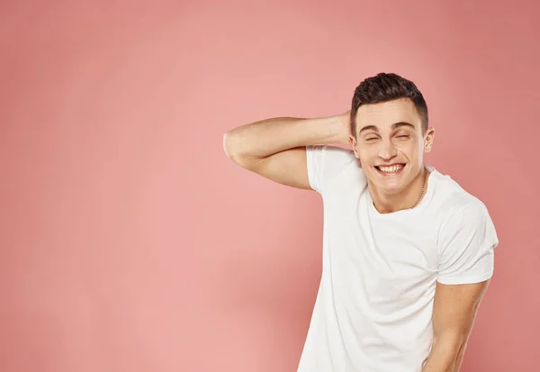 Stilig man i vit t-shirt känslor glädje rosa bakgrund — Stockfoto