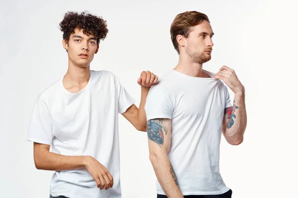 Dos hombres en camisetas blancas se paran lado a lado estudio vista recortada — Foto de Stock