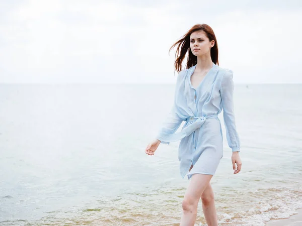 Un voyageur en robe bleue court le long du littoral sur la plage — Photo