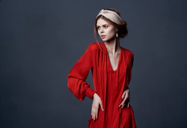 Kırmızı elbiseli zarif kadın. Lüks dekorasyon. Gri arka plan.