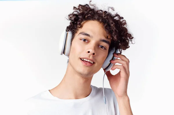 Chico de pelo rizado en los auriculares escuchando música recortado ver emoción — Foto de Stock