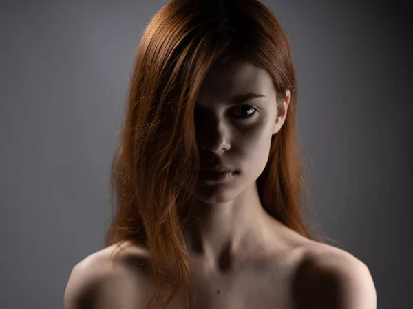 Mujer modelo close-up hombros desnudos pelo rojo fondo oscuro —  Fotos de Stock