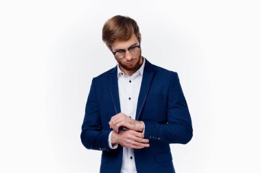 Klasik takım elbiseli sarışın adam ceketinin kollarını kırpıştırıyor.