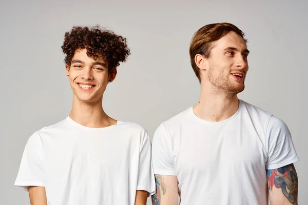Dos amigos alegres en camisetas de pie al lado de la alegría de fondo aislado — Foto de Stock