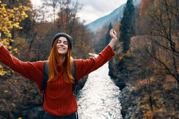 woman with hands raised up on nature in the mountains Autumn forest