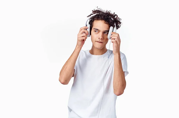 Kulaklık takan yeni teknolojili beyaz tişört giyen bir genç. Arka plan müzik modeli. — Stok fotoğraf