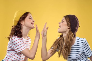 Komik anne ve kız şapkalar giyiyorlar. Eğlenceli eğlence ailesi sarı arka plan.