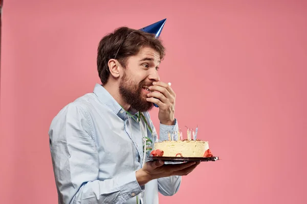 Barbudo hombre con pastel en rosa fondo cumpleaños fiesta corporativa emociones modelo soledad — Foto de Stock