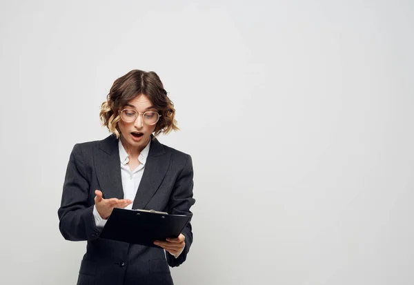 Una donna con documenti in una cartella su uno sfondo leggero gesti con le mani — Foto Stock