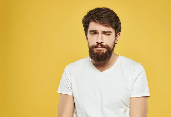 Un hombre moreno con barba gruesa sobre un fondo amarillo emociones modelo —  Fotos de Stock