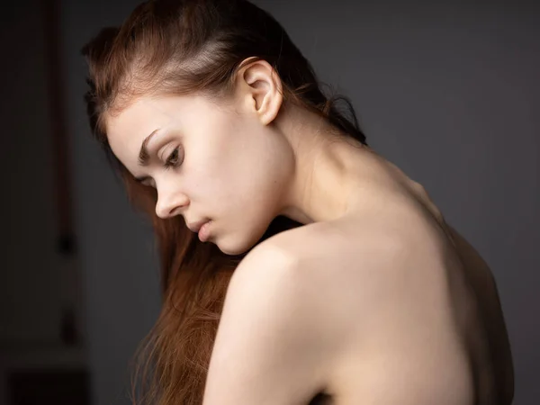 一个性感女人，赤身露背，灰色背景，红头发，后视镜 — 图库照片