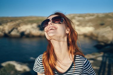 Dağlarda açık havada gözlük takan bir kadının portresi. Turizm temiz su gölü nehrinde seyahat ediyor.