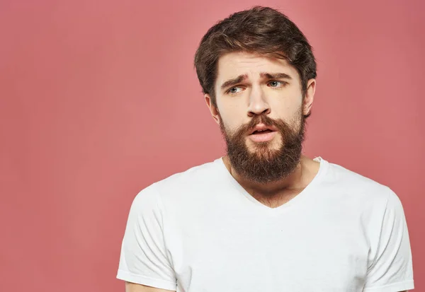 Triste hombre sobre fondo rosa vista recortada de camiseta blanca y barba tupida —  Fotos de Stock