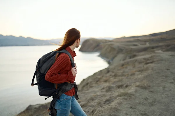 Donna sale sulle montagne e guarda il mare in lontananza paesaggio nuvole viaggi turismo — Foto Stock