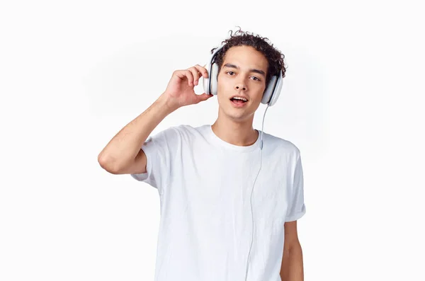 Hombre con el pelo rizado escuchando música con auriculares adolescente moda nueva tecnología camiseta — Foto de Stock