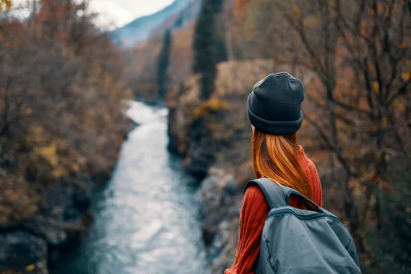 Mulher com mochila na natureza na ponte perto das montanhas do rio aventura — Fotografia de Stock