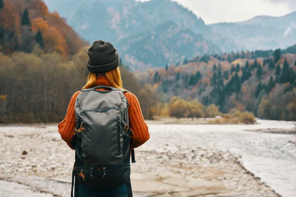 Mulher feliz na floresta de outono nas montanhas ao ar livre com uma mochila em suas costas turismo de viagens — Fotografia de Stock