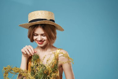 Bir buket çiçekli şapkalı kadın bayram kadınlarının cazibesi mavi arka planda