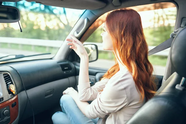 Woman fellow traveler in a car salon in the front seat design open window nature — Stock Photo, Image