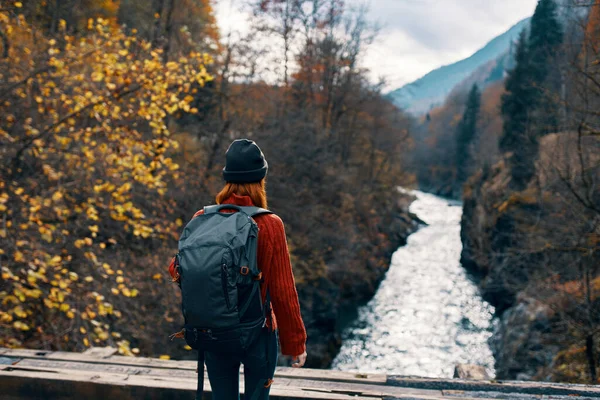 Femme touriste se tient sur le pont sur la rivière ou admire le paysage naturel — Photo