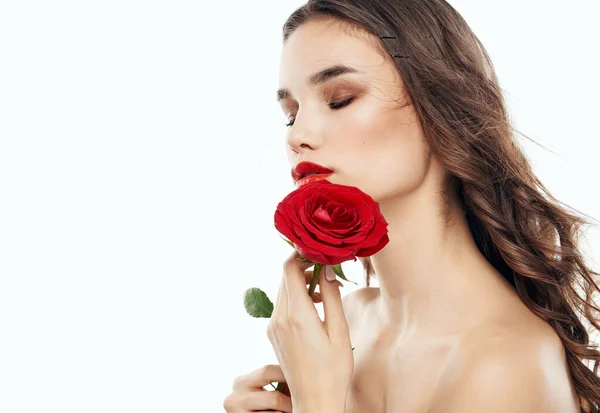 Affascinante donna bruna con le spalle nude e un fiore profumato vicino al suo viso — Foto Stock