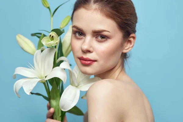Encantadora mujer con flores blancas sobre fondo azul retrato vista recortada — Foto de Stock