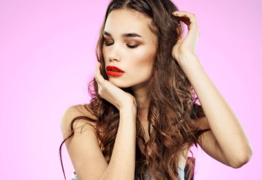 Kırmızı dudaklı, esmer ve pembe arka planlı seksi kadın modeli.