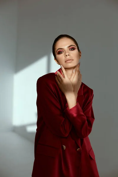 Mulher bonita com maquiagem brilhante no rosto segurar as mãos perto de glamour rosto casaco vermelho — Fotografia de Stock