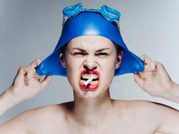 Mujer nadadora con gorra azul y gafas con un cigarrillo en los dientes — Foto de Stock