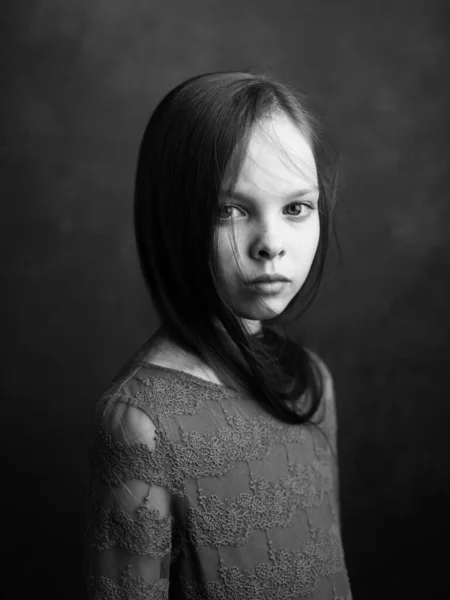 Portrait of a little girl in a dress on a dark gray background photograph cropped side view — Stock Photo, Image
