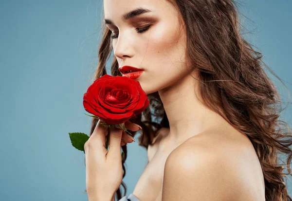 Femme sexy avec rose rouge et fond bleu avec des boucles brunes — Photo