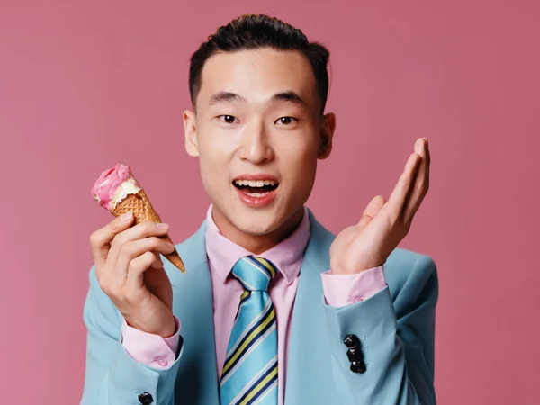 アジア人男上のピンクの背景ジェスチャーで彼の手とアイスクリームでコーン — ストック写真