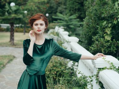 Yeşil elbiseli güzel bir kadın. Doğanın cazibesi. Yeşil yapraklar.