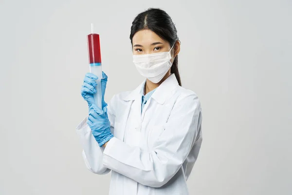 Woman doctor with syringe in hand and blue gloves medicine injection coronavirus — Stock Photo, Image